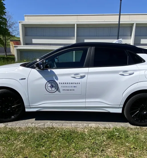 Silbernes Fahrschulauto seitlich geparkt in Dübendorf